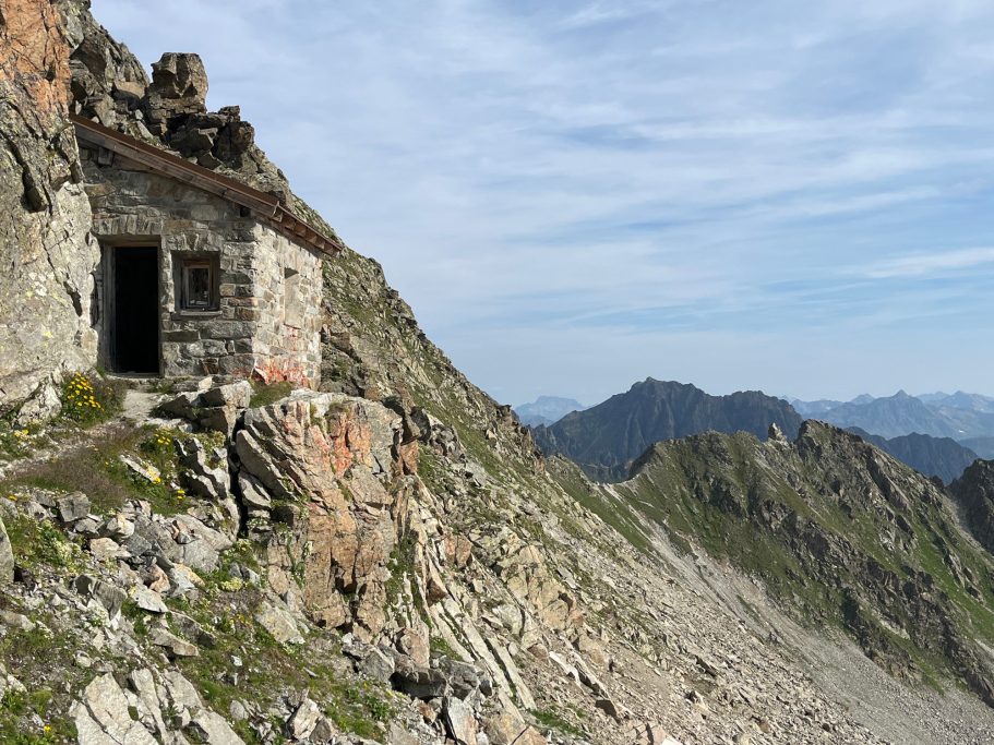 Seelücke Einfache Hütte auf einem Berghang mit Aussicht auf umliegende Berge.
