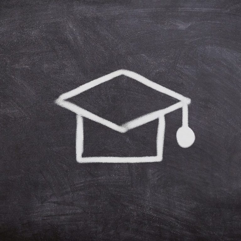 Absolventenhut auf einer schwarzen Tafel gezeichnet.