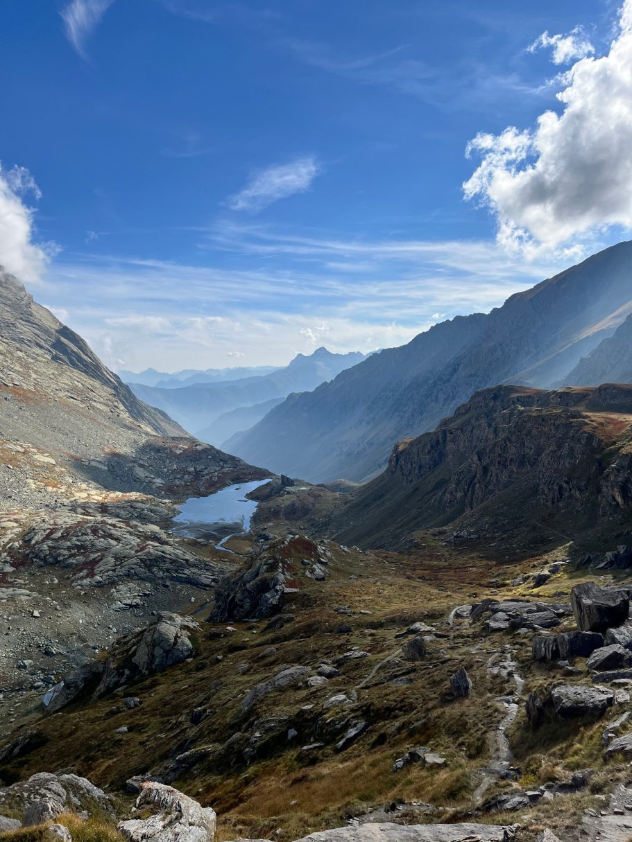 Monviso Berglandschaft mit einem klaren See und beeindruckenden Wolken am Himmel.